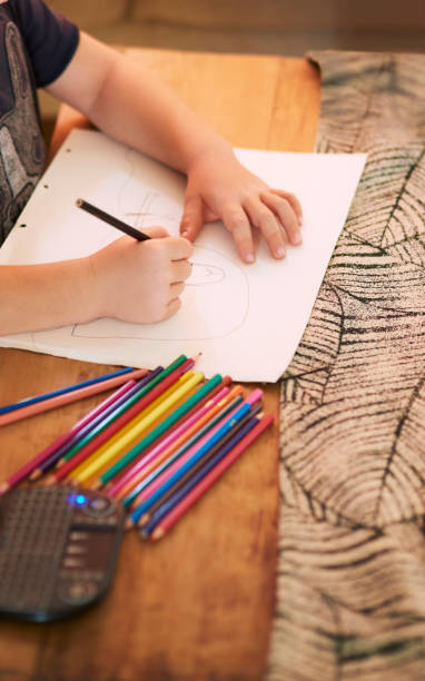 istock Kid hands, pencil crayons and drawing on paper at table of creative learning, homework or project. Closeup children, creativity and writing with color stationery, education development and art sketch 1479353468