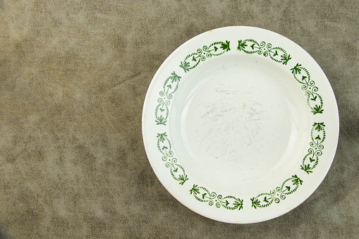 Empty tableware and dishware settings and serving on the gray background, plate, bowl and vintage spoon