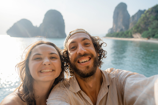 Selfie of young Caucasian woman and man on cliff  on the background of  Railey  bay
