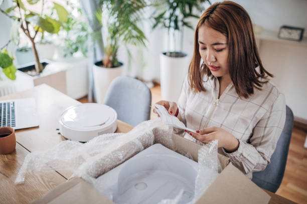 istock Discovering the future of cleaning: Asian millennial tests robot vacuum 1479356377