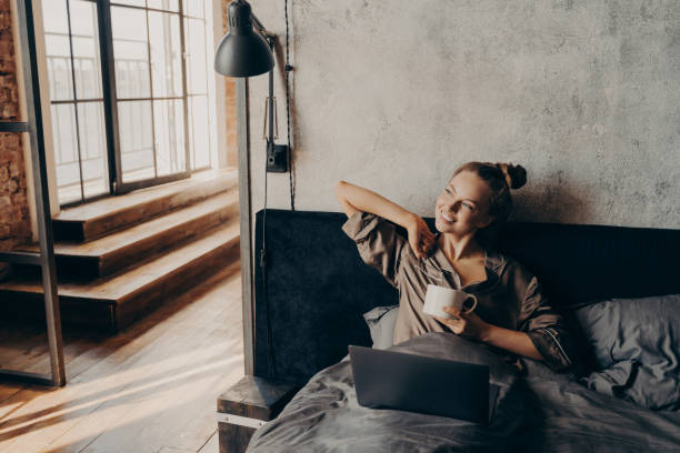 istock Happy relaxed positive young girl freelancer drinking coffee before to start working remotely at home 1479356379