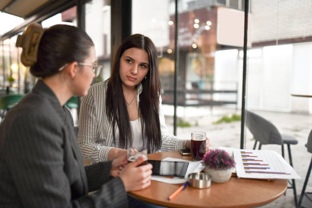 istock Female Beauties Drinking Juice While Conversing Intently Regarding Company Financial Issues 1479357173