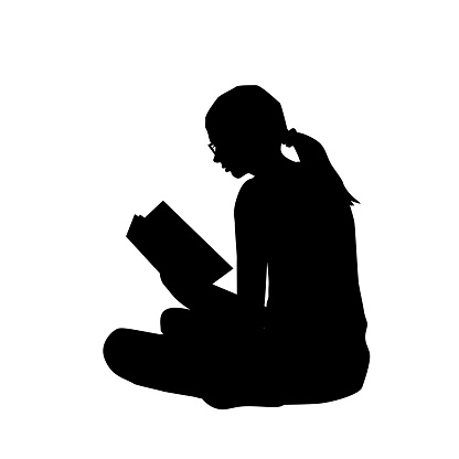 Silhouette  of a young woman reading a book