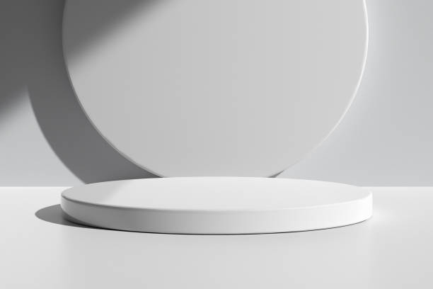 istock Glossy round podium on table counter with natural light and shadow on the white wall. 1479360609