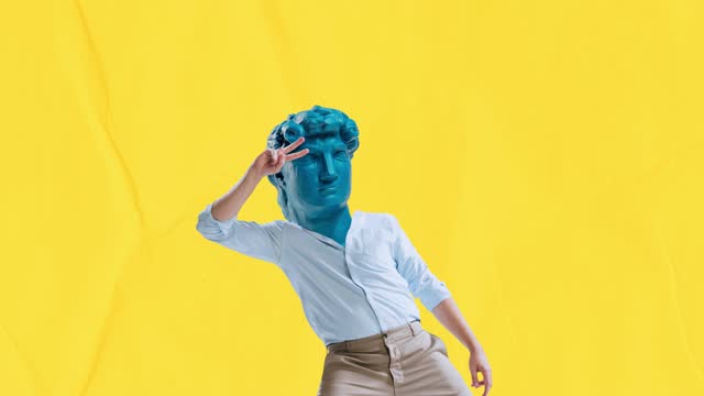 Stop motion, animation. Young man in classical clothes headed by blue antique statue head dancing on yellow background. Contemporary colorful and conceptual bright art collage