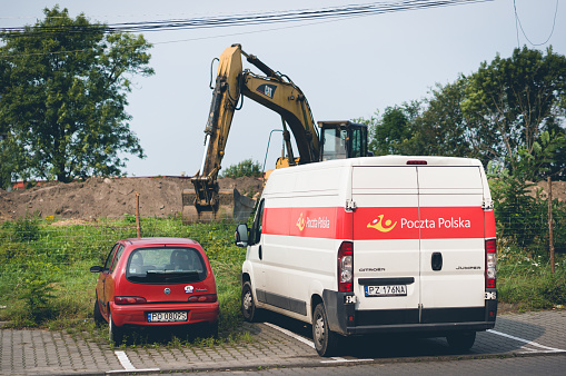 Poznan, Poland – September 11, 2017: Parked red Fiat Seicento car and Poczta Polska Van  on parking spots