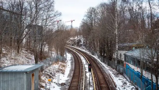 A scenic view of a city with a train track on a hill in the winter season