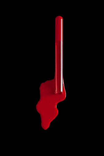 A Chemical Glasswork Test Tube with spilled red fluid isolated on a Black Background