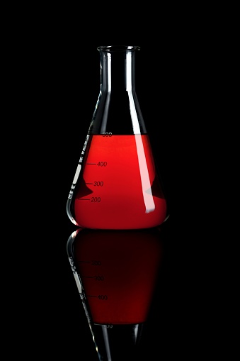 A Chemical Glasswork Erlenmeyer with Red Fluid isolated on a Black Background