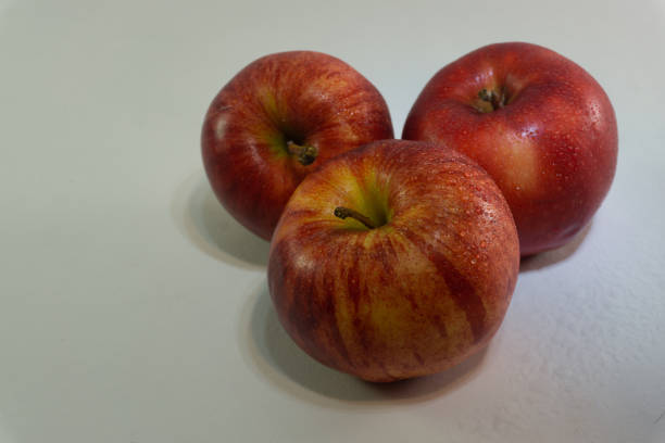 istock Closeup shot of three red apples on a gray background 1479364728