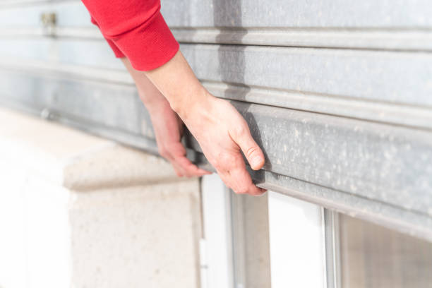 istock Man's hand closing metal roller shutter door 1479365200