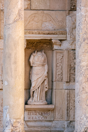 An ancient marble statue of a woman in a toga. Part of the exterior of The Celsus Library of Ephesus Ancient City.