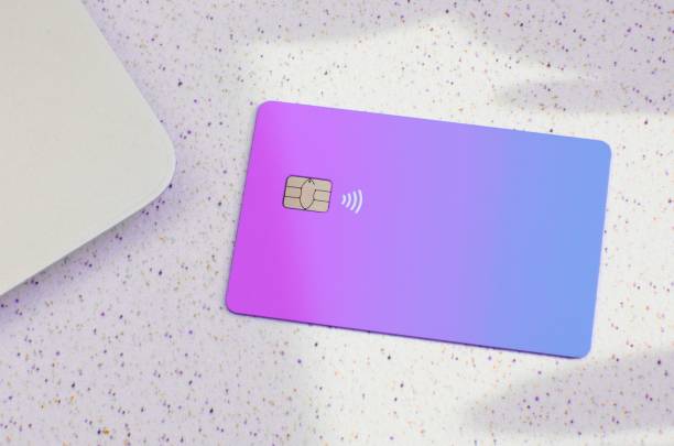 istock Closeup of a gradient purple and blue credit card isolated on an empty surface 1479366264