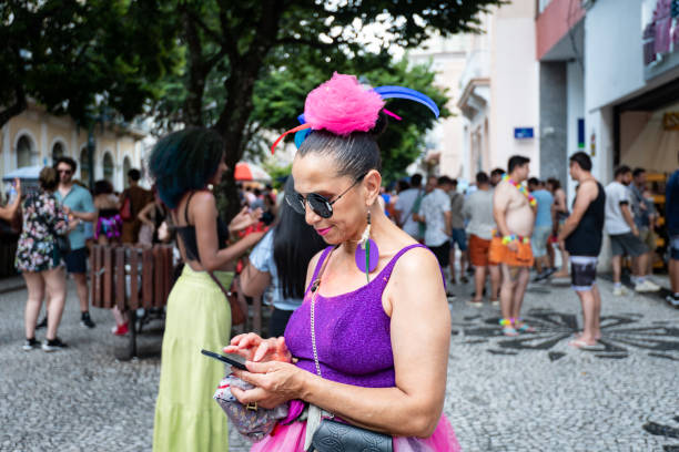 Woman dressed for carnival typing on her mobile stock photo