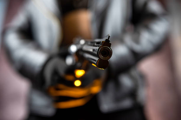 istock slim woman in a black jacket holding gun 1479367901