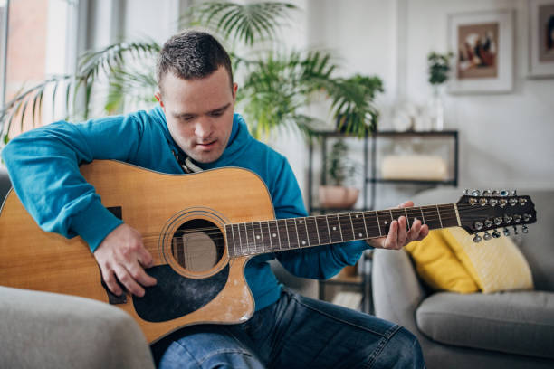 istock Down syndrome man playing a guitar in the livingroom 1479367996