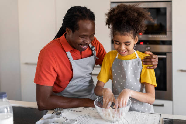 istock Black girl and her father kneading dough while baking in kitchen 1479369552
