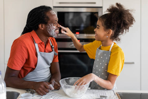 istock Cheerful Black Dad And Daughter Playing With Floor While Baking In Kitchen 1479369565