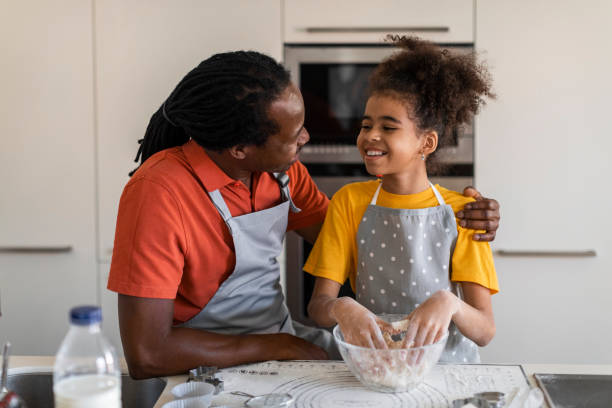 istock Happy black dad and daughter baking pastry together at kitchen 1479369575
