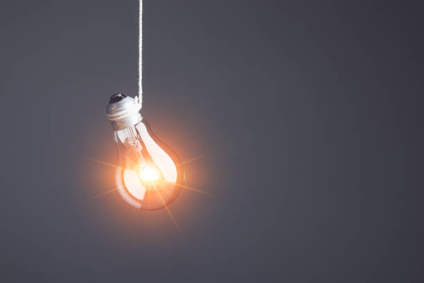istock Finding the new inspiration concept, Clear light bulb hanging on a rope with grey space wall background. Use for the idea of future creative innovation, Learning, Education or working, Studio shot. 1479371474