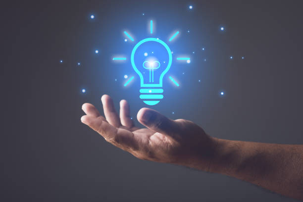 istock Ideas for designing new things, Using new technologies to innovate in the future, hand holding a blue illuminated light bulb. Brigh and creativity concept. 1479371752
