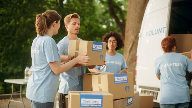 istock Happy Group of Volunteers Working on Delivering Humanitarian Aid and Donations, Loading Boxes into a Cargo Van. Successful Charity Workers High Five Each Other. 1479372201