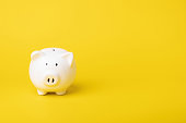 Financial concept, The idea of saving money, Close up white new piggy bank on yellow color copy space background. Saving money, Finance or business concept.