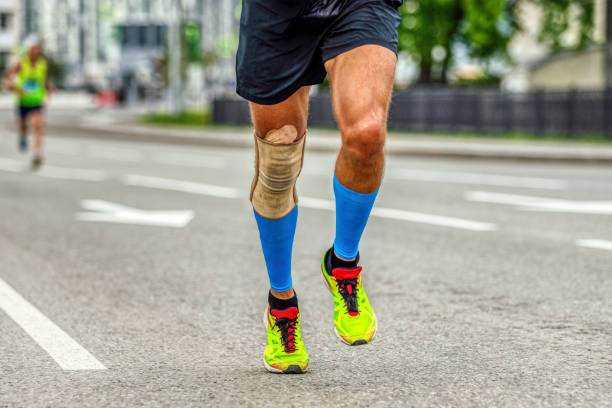 istock legs man runner in knee pads and compression socks running marathon, protection knee sleeve after injury to stabilization 1479372821