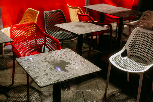 street cafe in Paris in rainy day, red wicker chairs and tables