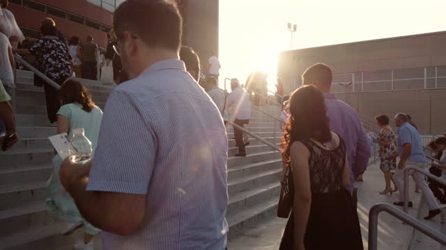 Customers walking the stairs in line at entrance of Armeec hall at sunset
