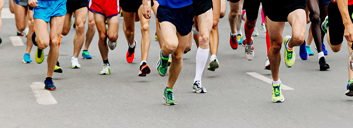 large group legs male runners run marathon, athletes jogging city race, summer sports event