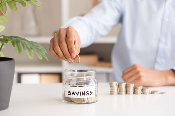 istock Close-up Businessman throws money into savings jar 1479375811