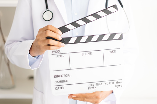 Close-up doctor holding clapperboard