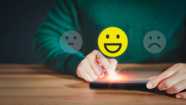 istock Man hand using a mobile phone with popup smile face icon for feedback review satisfaction service and testimonial. Customer service experience assessment and business satisfaction survey. 1479376133