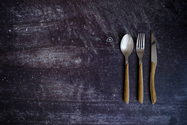 istock Spoon, fork and knife on a rustic wooden table 1479379395