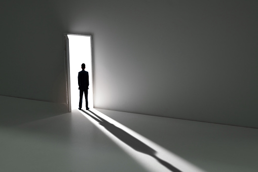 Businessman standing in front of open door