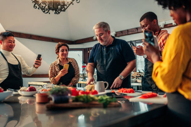 istock Students using mobile phones to record chef giving lecture in cooking class. 1479382412