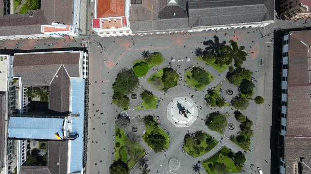 Top view of the green trees at the main square in Quito, Ecuador with people walking in the streets