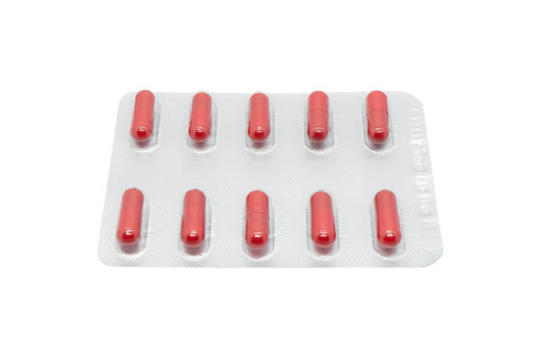 istock Macro shot pile of red tablets pill in silver blister packaging isolated on white background. Aluminium foil blister pack. Pharmacy products. Medicine pills and drugs. Pills background 1479384300