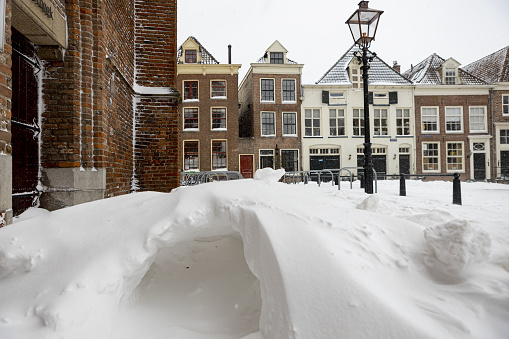 Zutphen, Netherlands – February 08, 2021: Thick pack of snow in the streets of historic city center of medieval Hanseatic town Zutphen during a snowstorm forming a kind of natural igloo cave