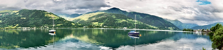 A boat on the lake in summer. Yachts stand on Lake Zell in summer. Sailing boats are on the water. Sailing boats stand on Lake Zell in Austria.