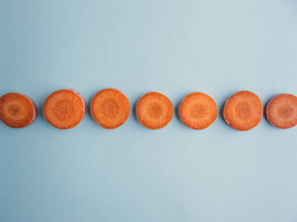istock Line of carrot slices on a blue background 1479392749