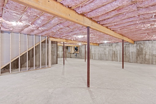 The unfinished home basement with the ceiling and concrete walls under construction