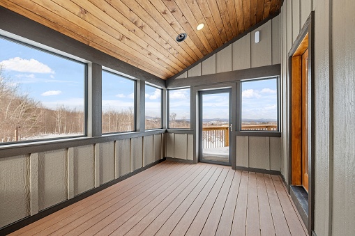 An empty balcony with doors and a sliding glass door opens to the outside