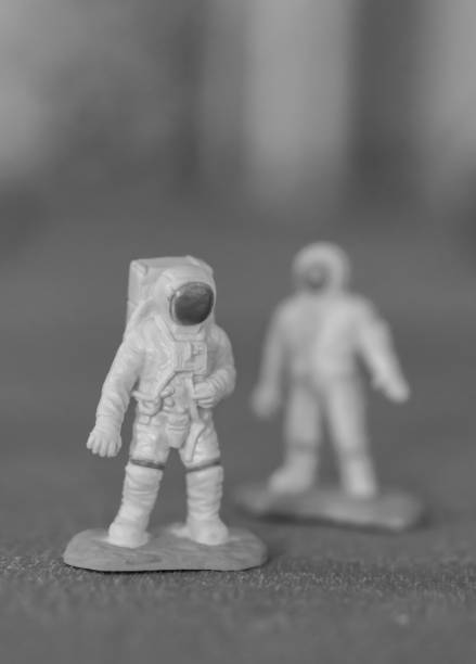 istock Vertical grayscale shot of astronaut toy figures on a green surface 1479405309