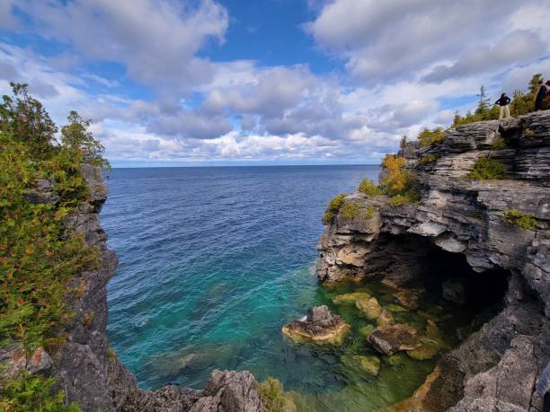 istock Majestic cliff with lush greenery overlooking a tranquil sea below. 1479408570