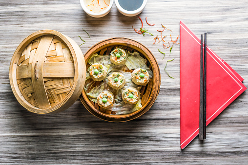 Vegetable Sui Mai with sauce and chopsticks isolated on wooden board top view on table fastfood