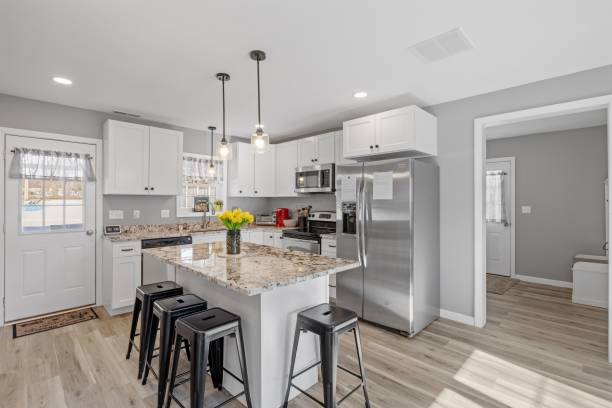 Modern kitchen with white walls and cabinets, featuring stainless steel appliances