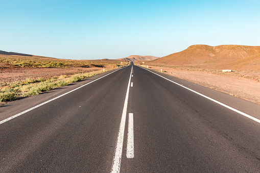 An empty long and straight country road on New Zealand's South Island.