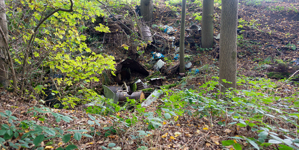 Fly tipping- rubbish oil drums and cans and a large quantity of garbage, trash and rubbish thrown into woodland in rural Shropshire by criminals who don’t want to pay for its legal removal.
